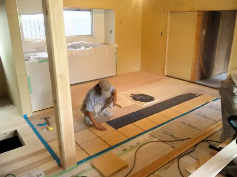 床にタイルを貼る工務店の職人